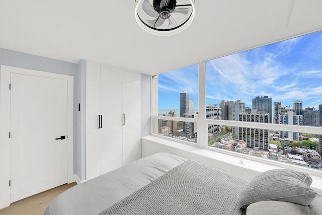 bedroom with a city view and wood finished floors