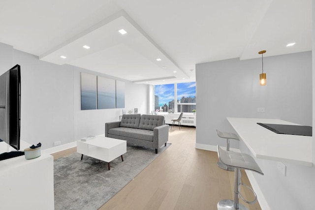 living room with wood finished floors, baseboards, and recessed lighting