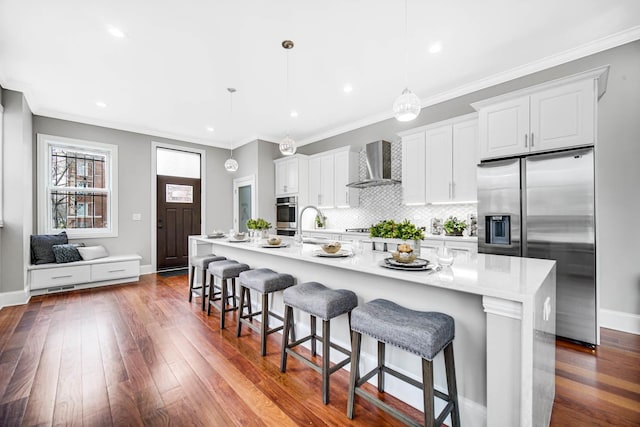 kitchen featuring dark wood-style floors, appliances with stainless steel finishes, tasteful backsplash, and wall chimney range hood