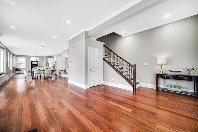 living area featuring wood finished floors, recessed lighting, stairway, crown molding, and baseboards