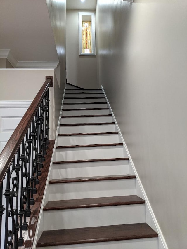 stairway featuring ornamental molding