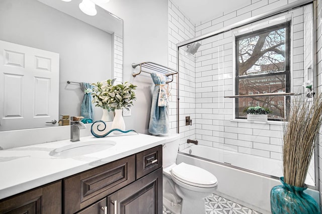 full bath with toilet, vanity, and bath / shower combo with glass door