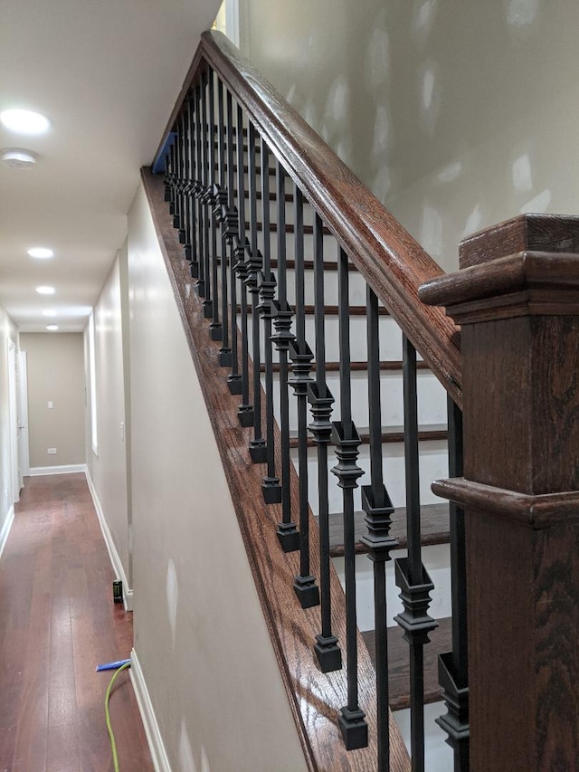 staircase featuring hardwood / wood-style flooring and baseboards