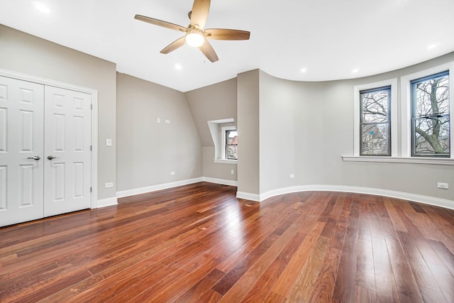 unfurnished living room featuring dark wood-type flooring, recessed lighting, and baseboards