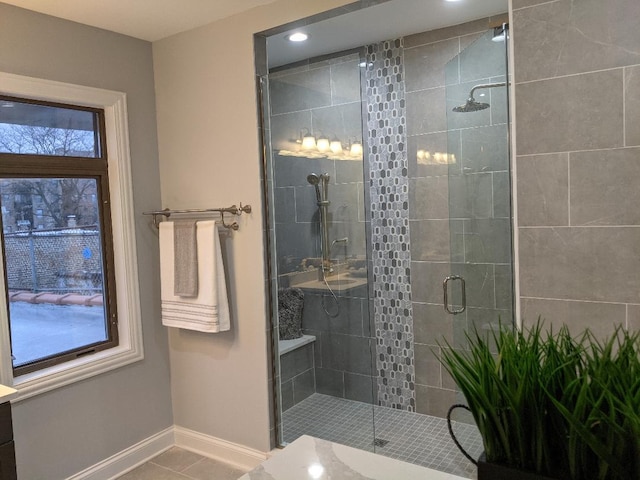 bathroom featuring tile patterned flooring, a stall shower, and baseboards