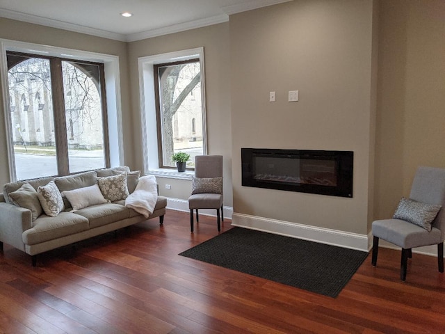 living room with baseboards, recessed lighting, hardwood / wood-style flooring, a glass covered fireplace, and crown molding