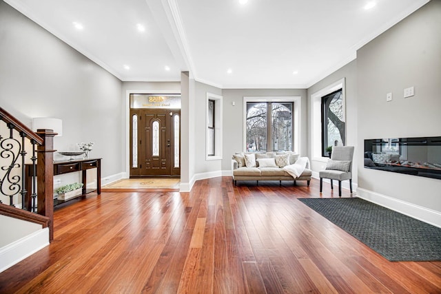 foyer entrance featuring baseboards, hardwood / wood-style floors, stairs, and crown molding