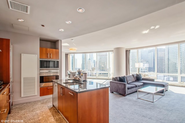 kitchen featuring visible vents, light colored carpet, stainless steel appliances, and a sink