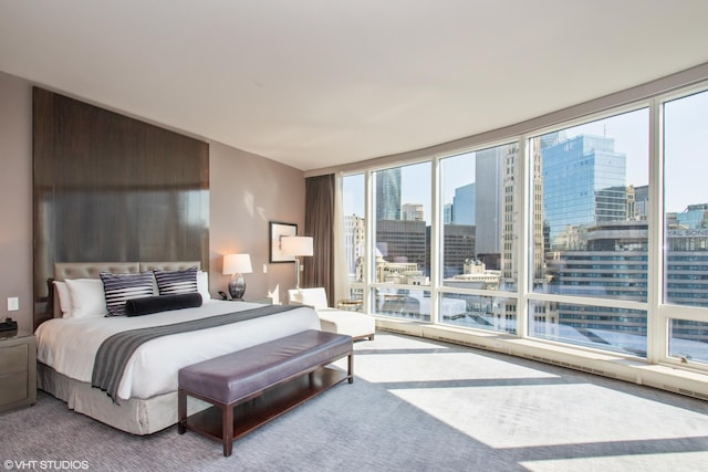 carpeted bedroom featuring a city view and a wall of windows