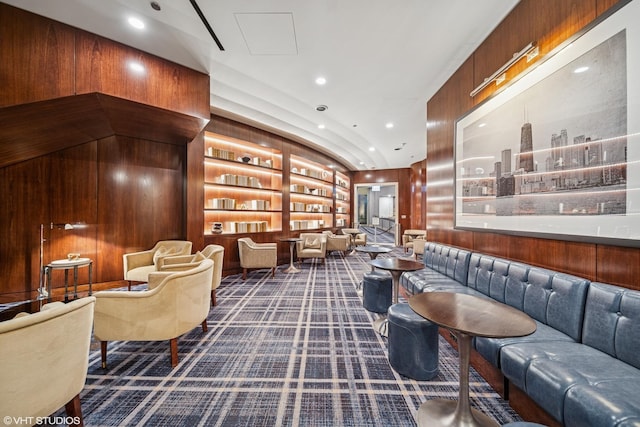 living area featuring recessed lighting, wood walls, built in shelves, and carpet