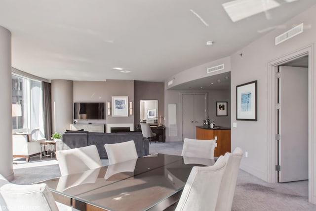 dining space with light carpet, visible vents, and baseboards