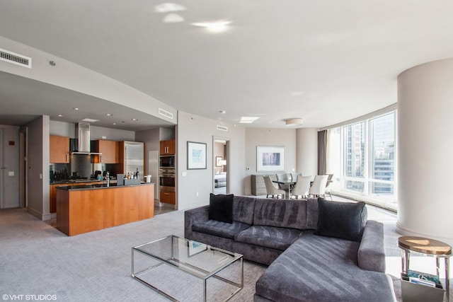 living area with recessed lighting, visible vents, and light colored carpet