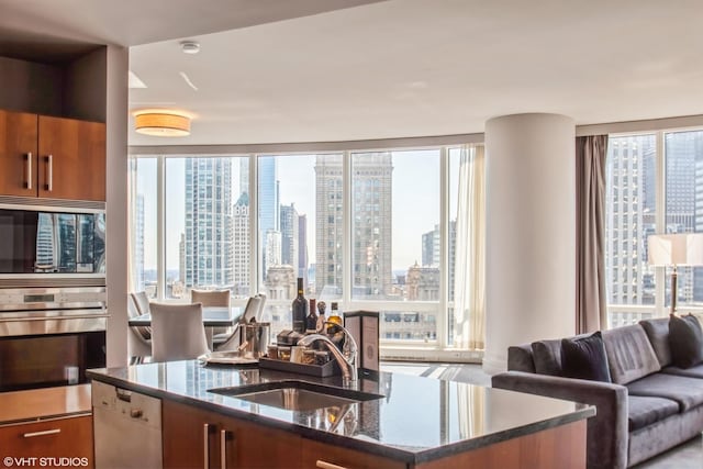 kitchen featuring a sink, plenty of natural light, a city view, and dark stone countertops