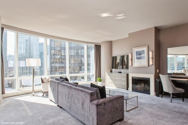 carpeted living room featuring a glass covered fireplace