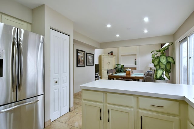 kitchen with light tile patterned floors, cream cabinets, recessed lighting, light countertops, and stainless steel refrigerator with ice dispenser