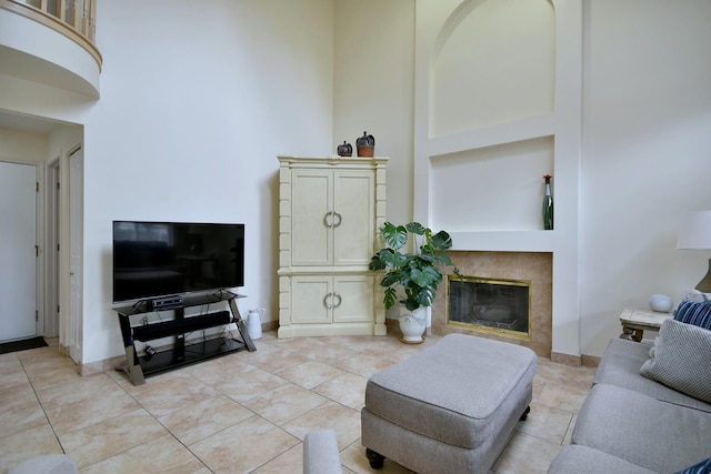 living area featuring a fireplace, a high ceiling, and light tile patterned floors