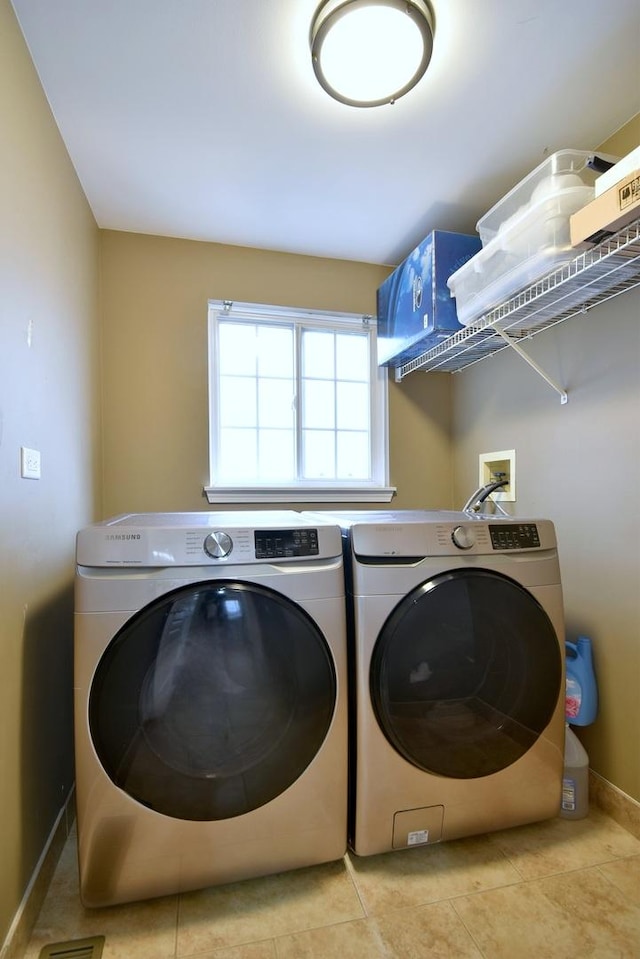 laundry area featuring laundry area, washer and clothes dryer, tile patterned flooring, and baseboards