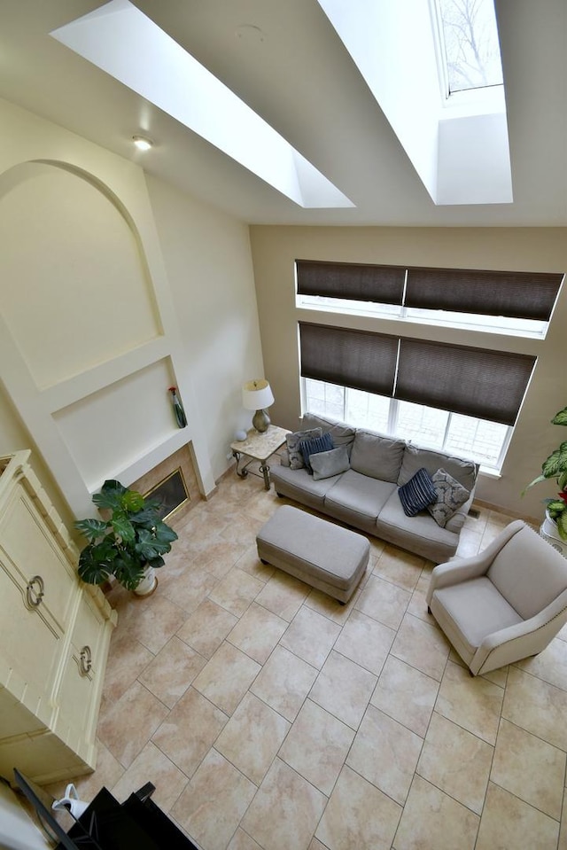 unfurnished living room featuring a skylight and light tile patterned floors