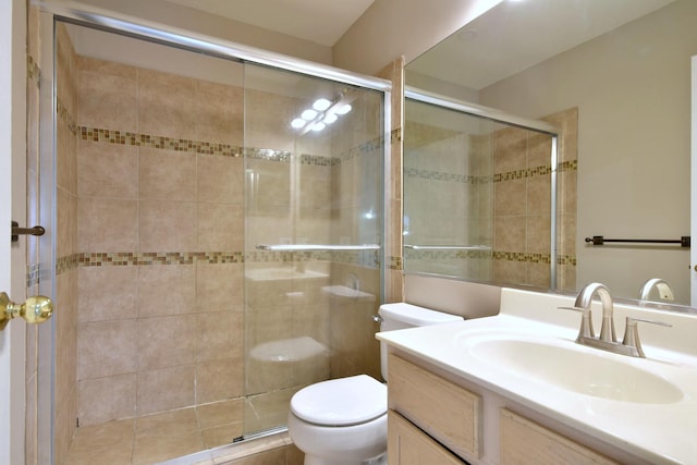 bathroom with toilet, a shower stall, and vanity