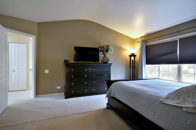 bedroom with lofted ceiling, baseboards, and carpet