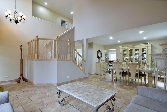 tiled living room featuring a chandelier, recessed lighting, a towering ceiling, baseboards, and stairway