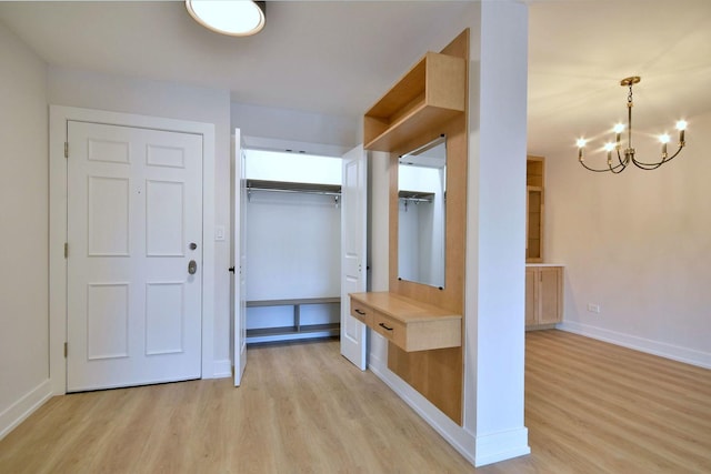 mudroom featuring baseboards, a notable chandelier, and light wood finished floors