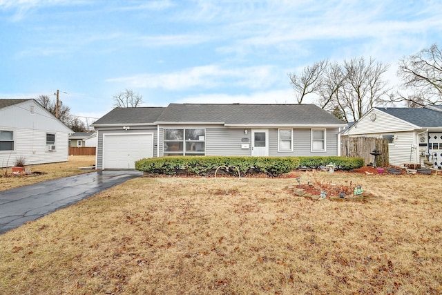 ranch-style home featuring aphalt driveway, a front yard, fence, and a garage