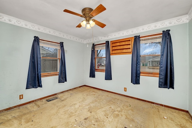 empty room with ceiling fan, a wealth of natural light, visible vents, and baseboards