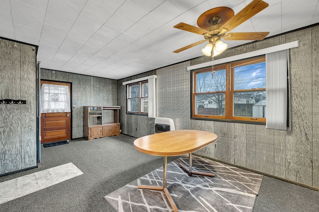 carpeted dining space with ceiling fan and heating unit