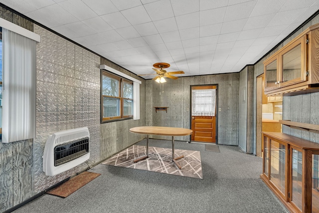 carpeted dining room featuring heating unit, a healthy amount of sunlight, and ceiling fan