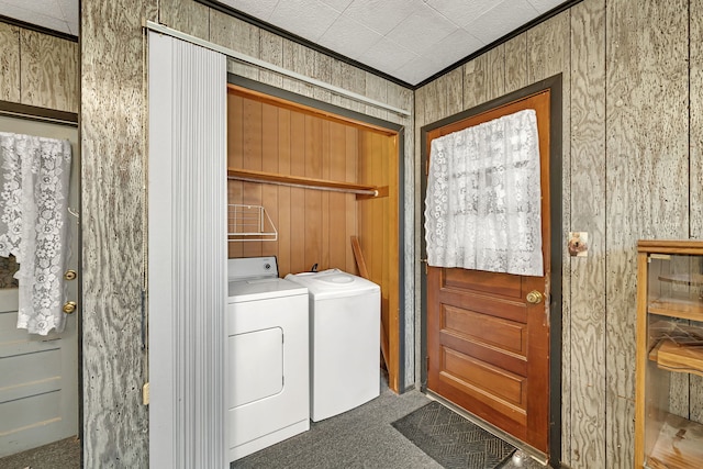 laundry area featuring laundry area, crown molding, carpet floors, wood walls, and separate washer and dryer