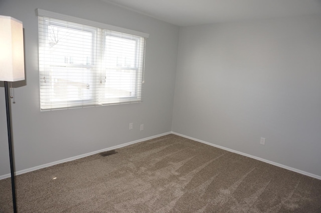 carpeted empty room with visible vents and baseboards