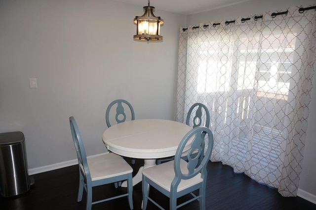 dining room featuring dark wood-type flooring and baseboards