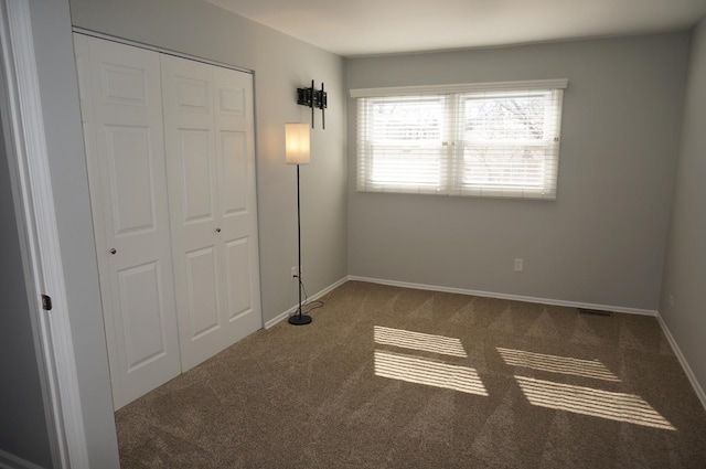 unfurnished bedroom featuring carpet floors, a closet, and baseboards