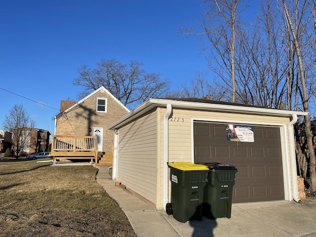 view of property exterior with driveway, a wooden deck, a garage, and an outbuilding