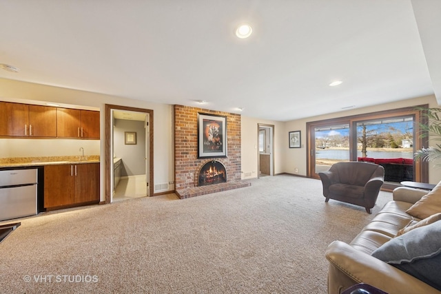 living area featuring a brick fireplace, baseboards, light colored carpet, indoor wet bar, and recessed lighting