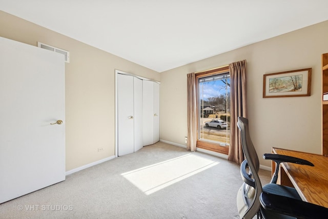 carpeted office featuring visible vents and baseboards