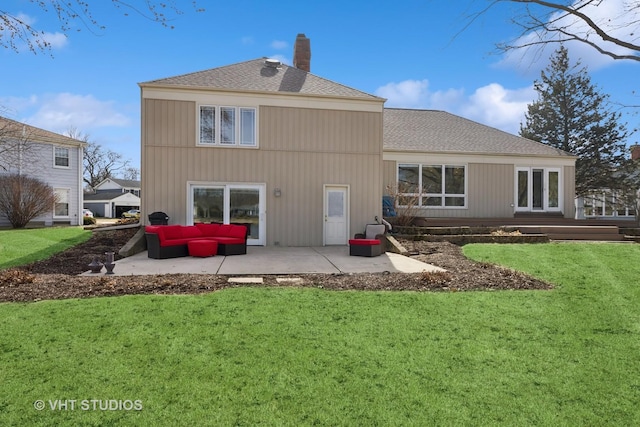 rear view of property with an outdoor living space, a patio, a yard, a shingled roof, and a chimney