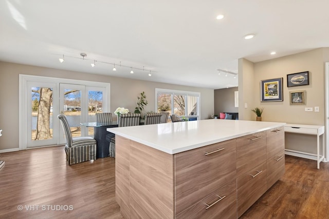 kitchen with a kitchen island, dark wood-type flooring, light countertops, recessed lighting, and modern cabinets