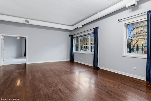 unfurnished room with visible vents, baseboards, and wood finished floors