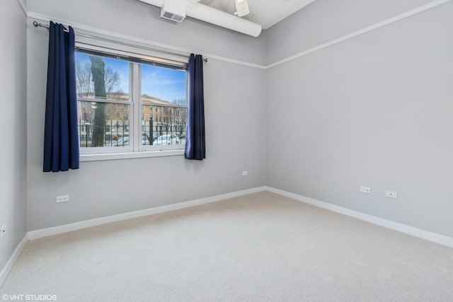 carpeted empty room featuring baseboards