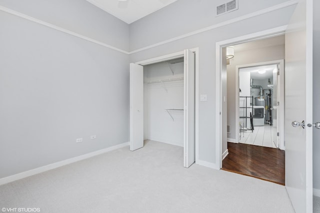 unfurnished bedroom with carpet, a closet, visible vents, and baseboards