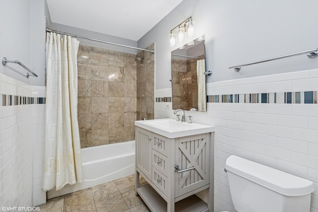 bathroom with toilet, a wainscoted wall, tile walls, vanity, and shower / tub combo with curtain