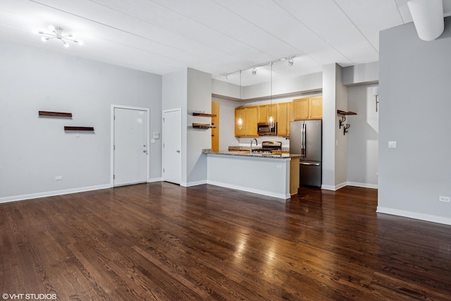 kitchen with baseboards, dark wood-style floors, appliances with stainless steel finishes, a peninsula, and pendant lighting