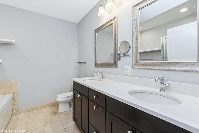 bathroom featuring toilet, tile patterned flooring, double vanity, and a sink