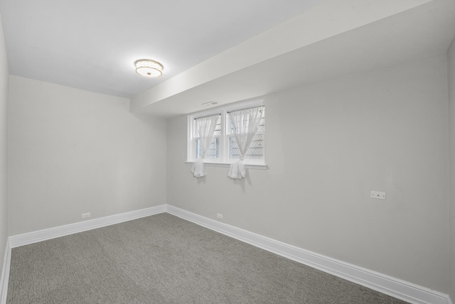 spare room featuring carpet flooring and baseboards