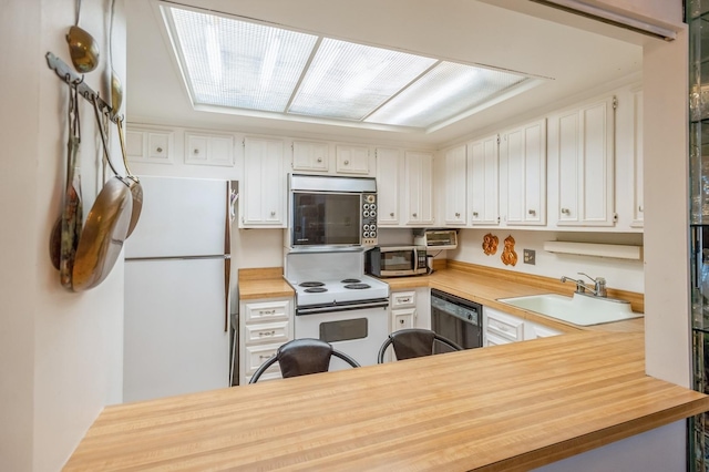 kitchen featuring wooden counters, white appliances, white cabinetry, and a sink