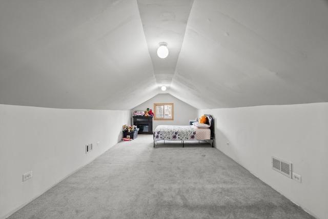 unfurnished bedroom with lofted ceiling, carpet flooring, and visible vents