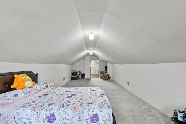 carpeted bedroom featuring lofted ceiling and visible vents