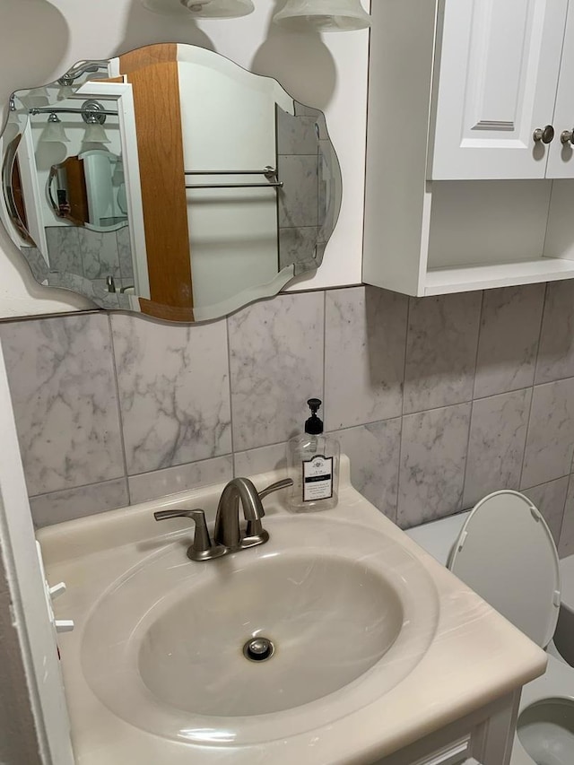 half bath featuring backsplash, toilet, and vanity